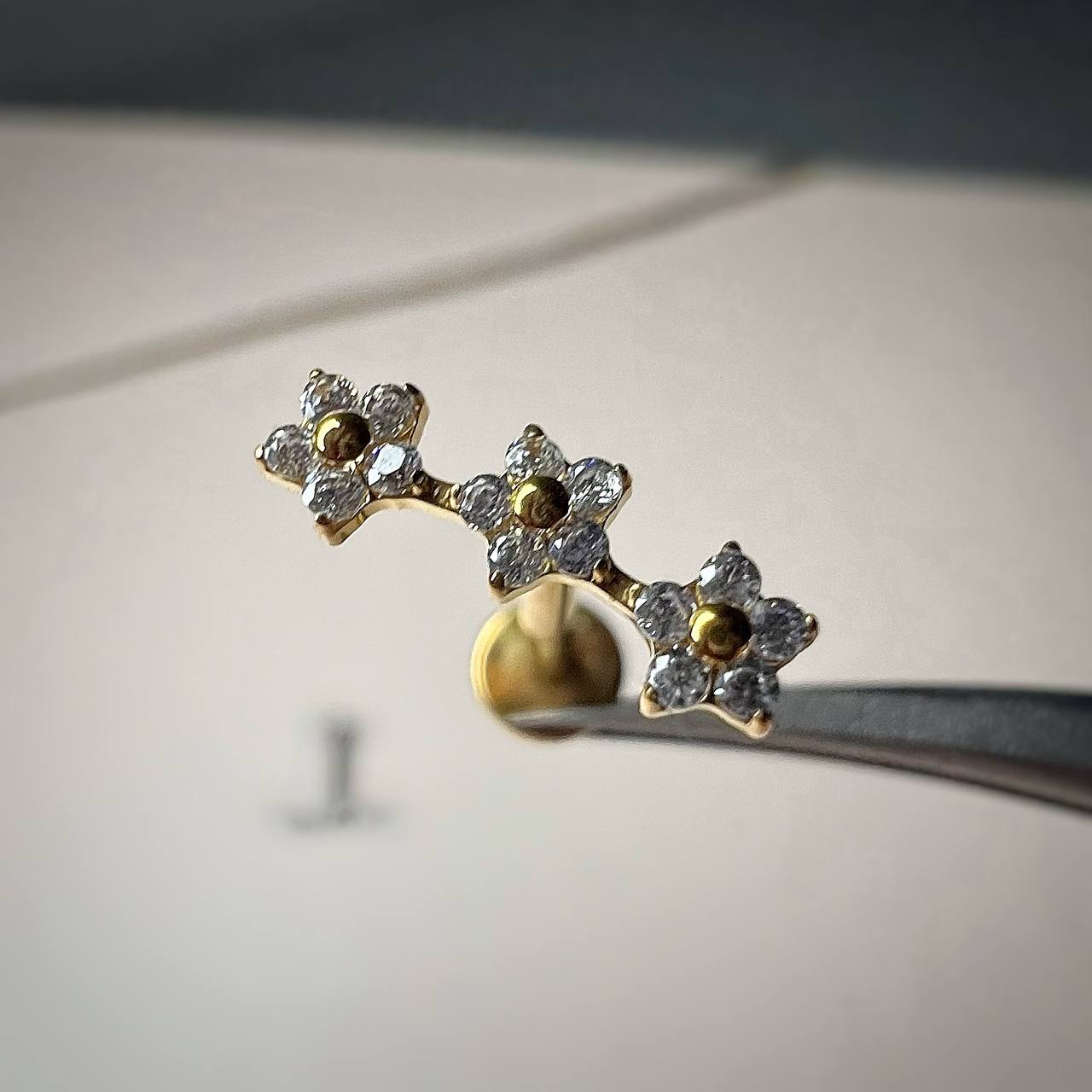 Kolczyk LABRET tytanowy Złoty z potrójnym motywem kwiatów i cyrkoniami ASTM F-136